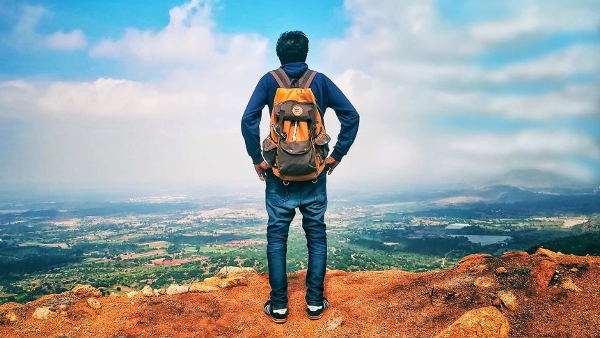 Man with backpack standing on mountain