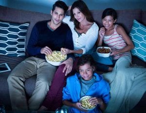 a family watching a movie and eating popcorn