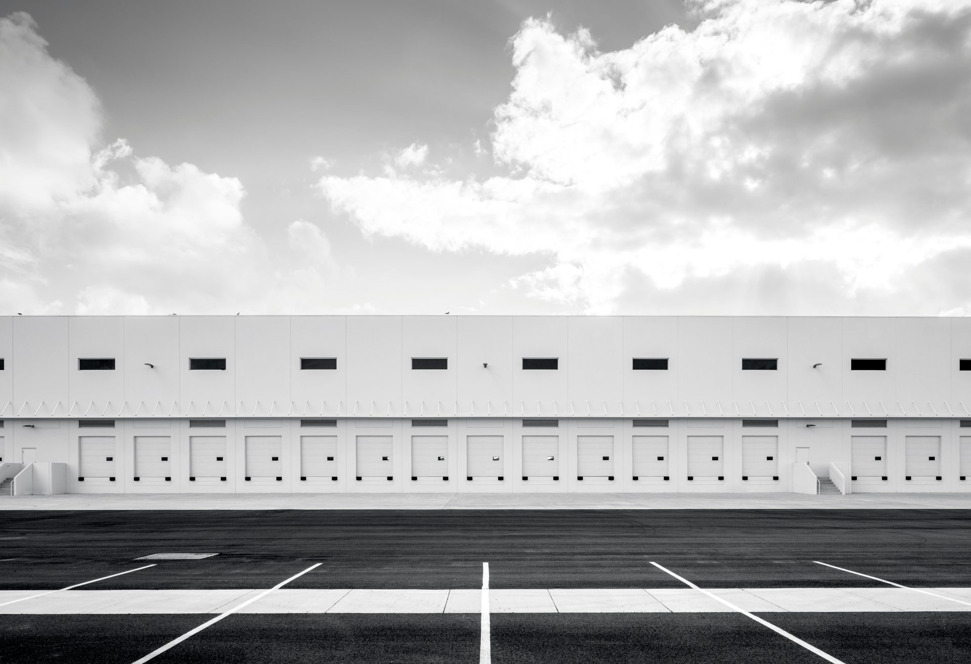 Black and white photo of a storage facility with several closed storage units