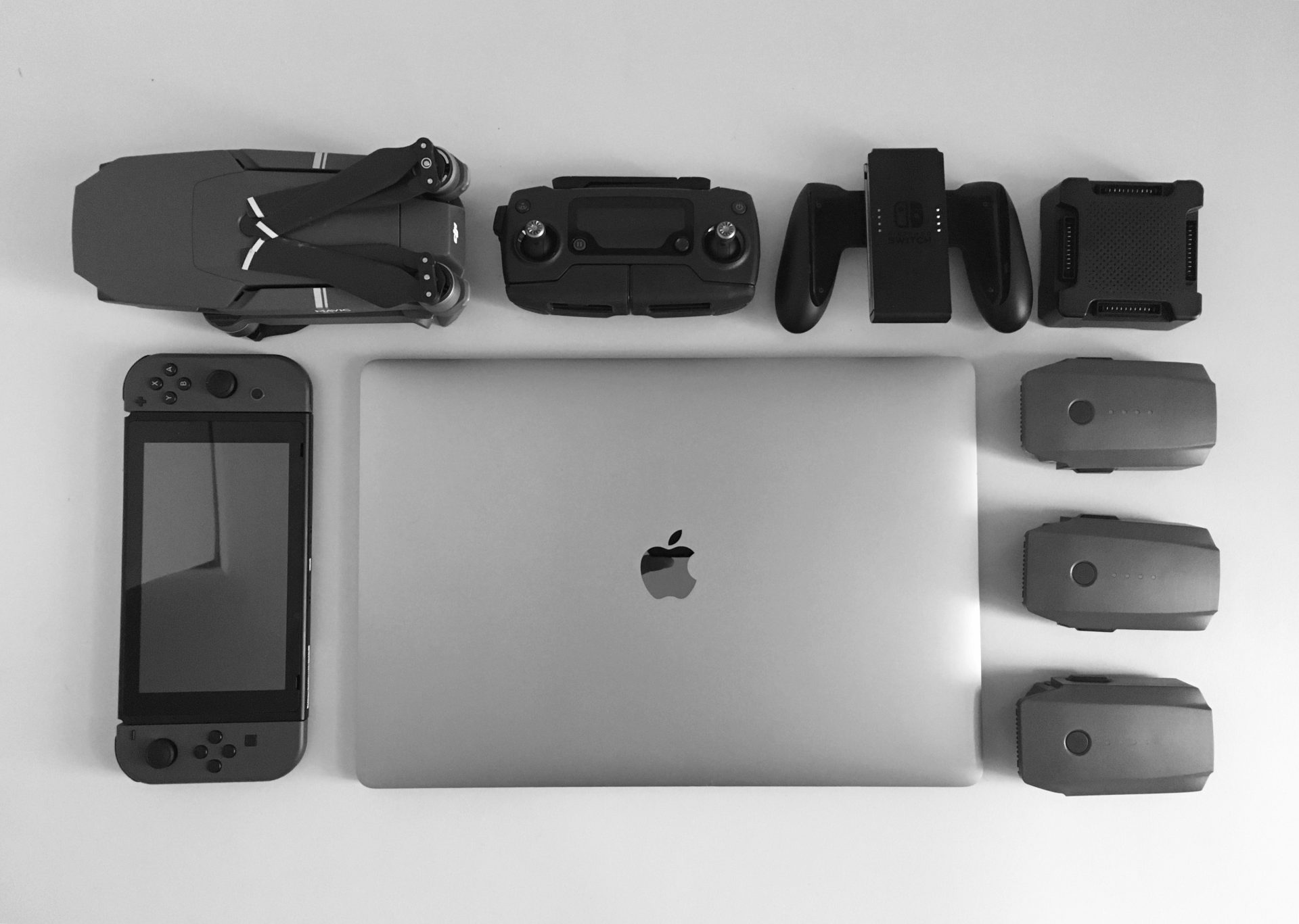 a flat lay of an assortment of laptops, cameras and mouse